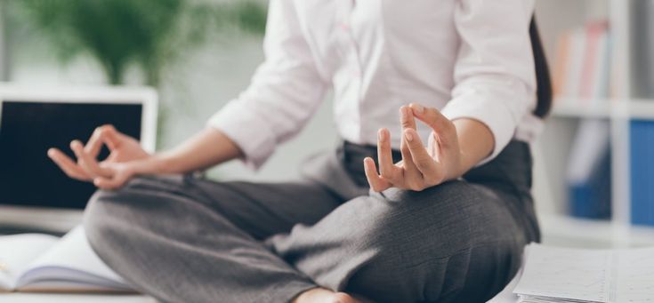 A person sitting in a calm posture at a desk, representing a lower-stimulation pause on a low-energy day