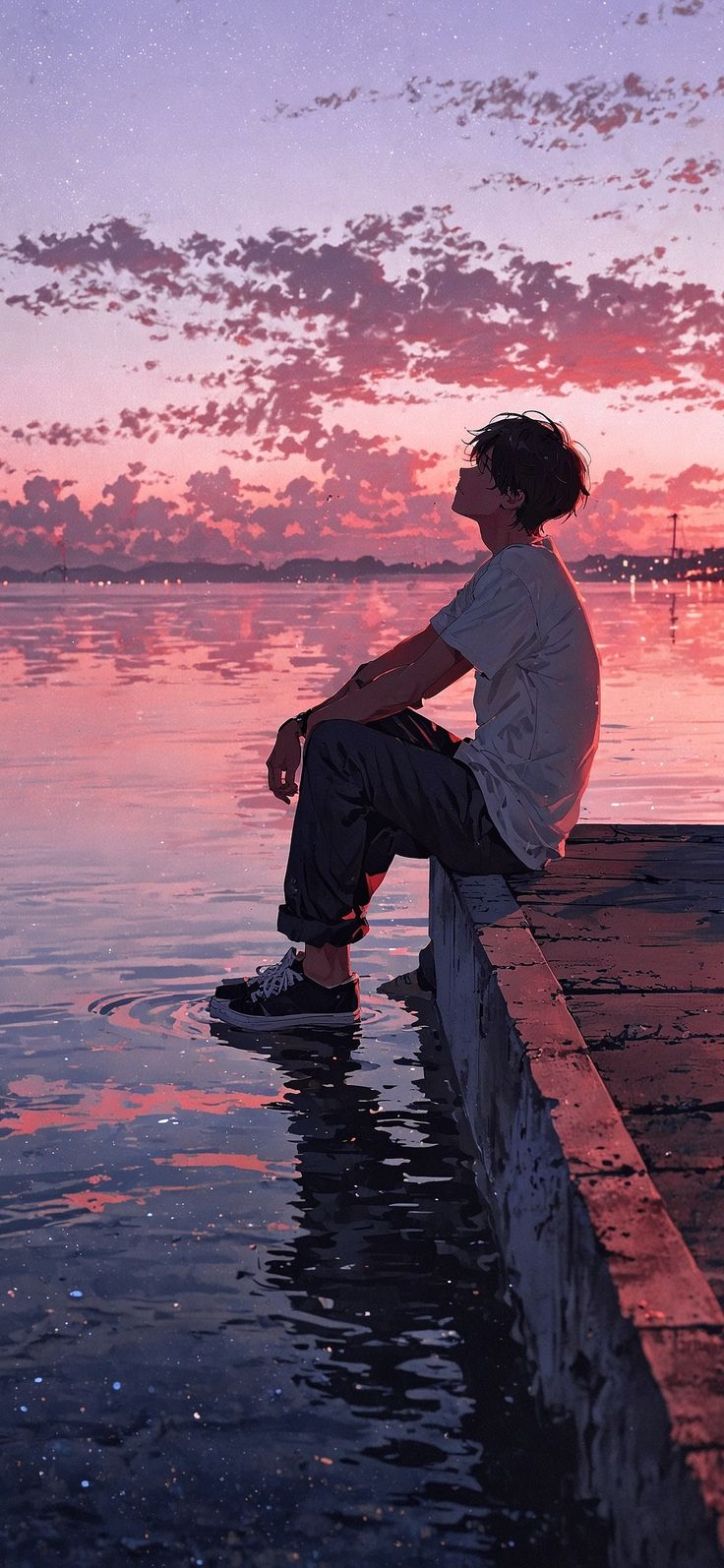 A person sitting quietly beside still water at sunset